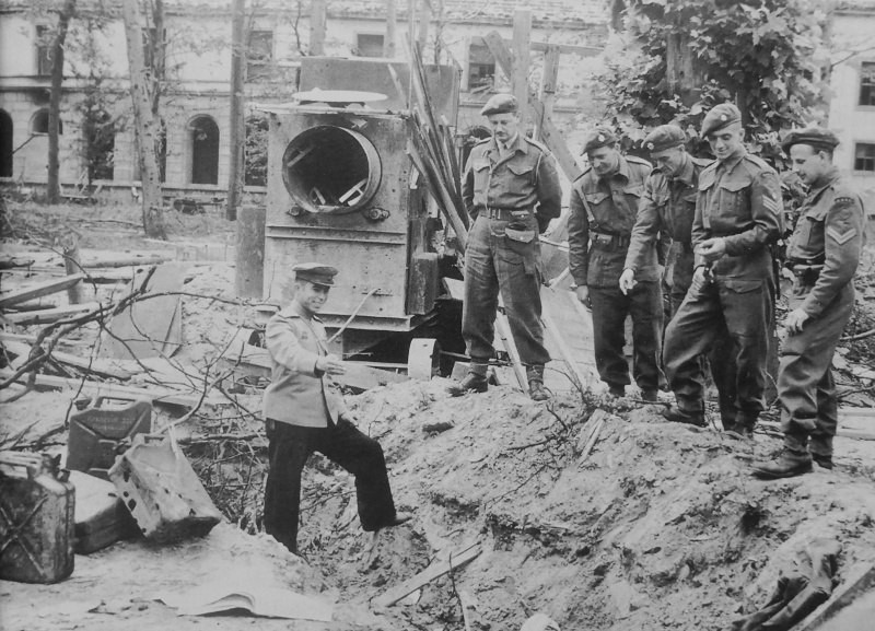 Советский офицер показывает британским военнослужащим место находки останков Гитлера.