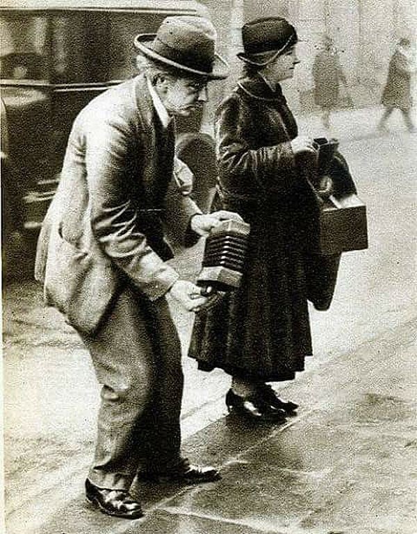 2. Лондон. Уличный музыкант играет на concertina.1920-ые годы