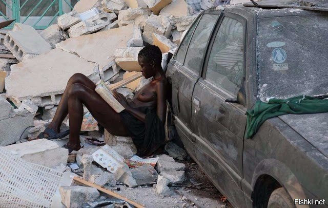 Женщина читает на обломках, после землетрясения