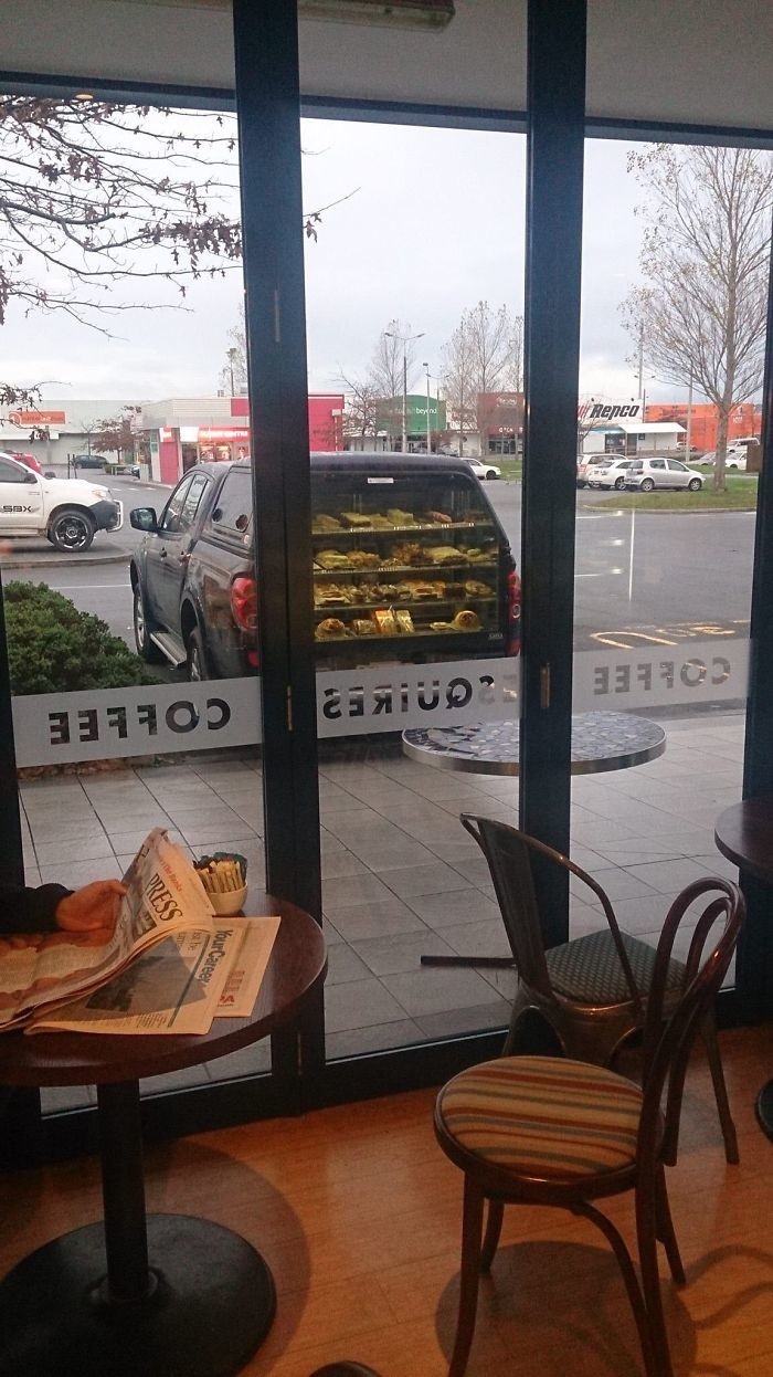 Эта машина не продает пирожные из багажника. Это лишь отражение прилавка кофейни, расположенного прямо напротив нее