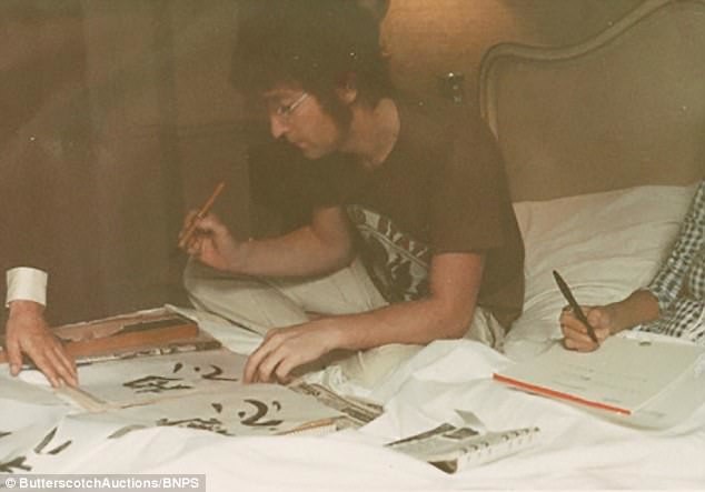 Джон Леннон сосредоточенно овладевает искусством японской каллиграфии