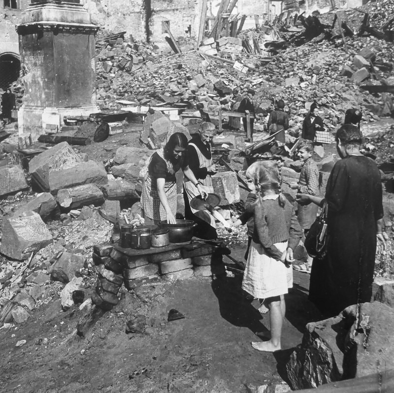 Жительницы Нюрнберга готовят пищу у руин разрушенных зданий.