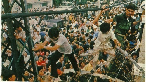 Вьетнамцы пытаются попасть в посольство США во время падения Сайгона, 1975 год.