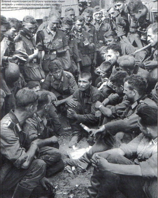 Немецкий военный корреспондент из роты пропаганды разговаривает с пленным красноармейцем. Лето 1941 года.