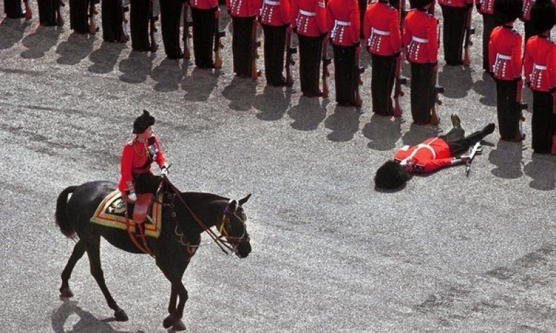 Гвардеец упал в обморок как раз в момент, когда королева Елизавета II проезжала на лошади во время парада. Лондон, 1970 год.