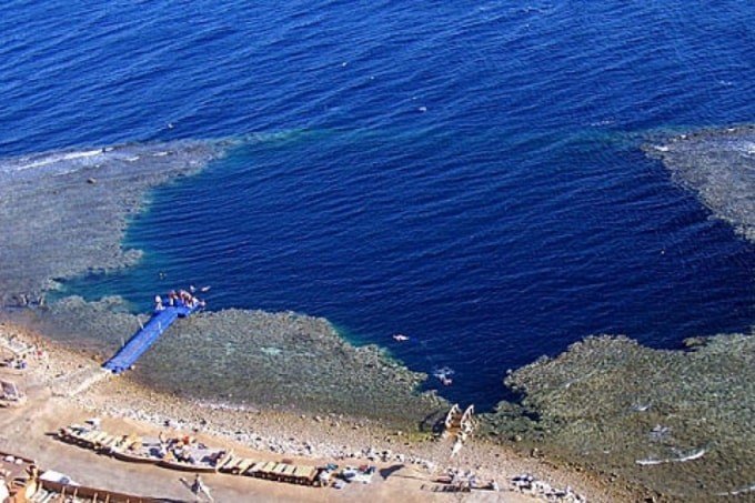 Вот это съемка «Голубой дыры» сверху. Видите покрытую водой тонкую перемычку, отделяющую «Блю холл» от моря? Арка с верхнего фото расположена несколькими десятками метров ниже.