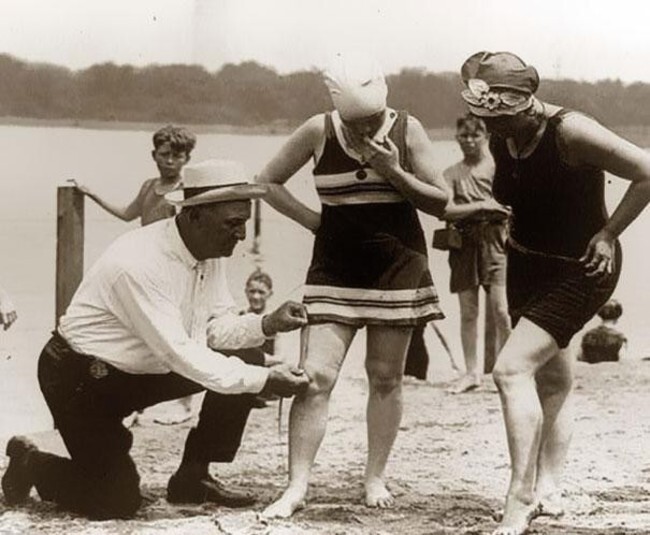 Официальный измеритель купальников на пляже проверяет, не слишком ли они коротки (1920)