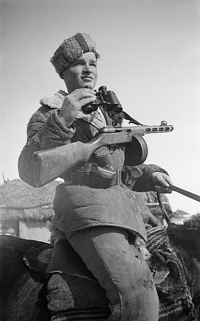 Портрет советского партизана с пистолетом-пулеметом ППШ и биноклем на коне.