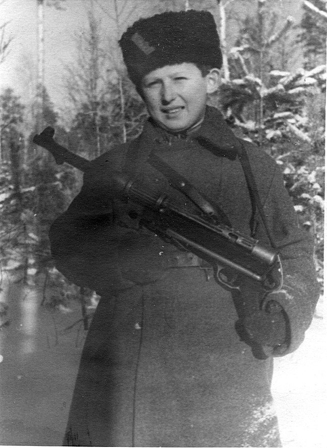 Советский партизан-подросток Коля Любичев из партизанского соединения А.Ф. Федорова с трофейным немецким 9-мм пистолетом-пулеметом МР-38 в зимнем лесу 1943 год.  Николай Любичев пережил войну и дожил до преклонных лет.