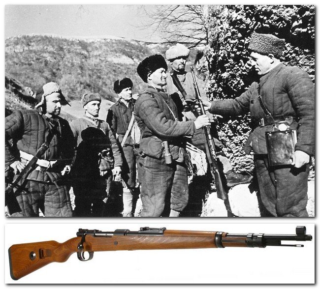 Командир советского партизанского отряда вручает 60-летнему бойцу, вступившему в отряд, трофейный немецкий карабин. Время съемки: 23-24.12.1942.