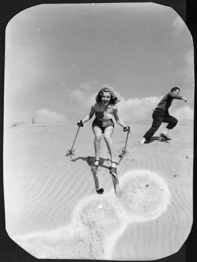Катание на лыжах по песчаной дюне для фотосессии.