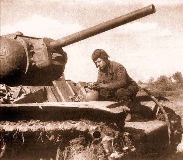 Танкист осматривает свой танк после боя на Курской дуге, 1943