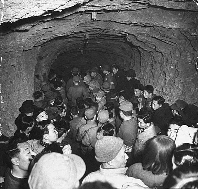 Люди, входящие в кустарное бомбоубежище. Чунцин, Китай, 1939.