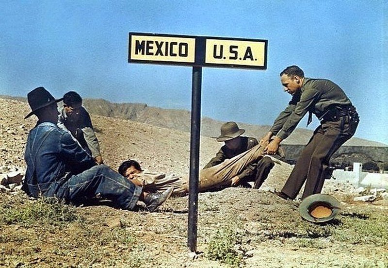  Два американских пограничника пытаются удержать беглеца, который уже успел частично пересечь границу с Мексикой.Эль-Пасо, штат Техас, США, 1 октября 1939 года
