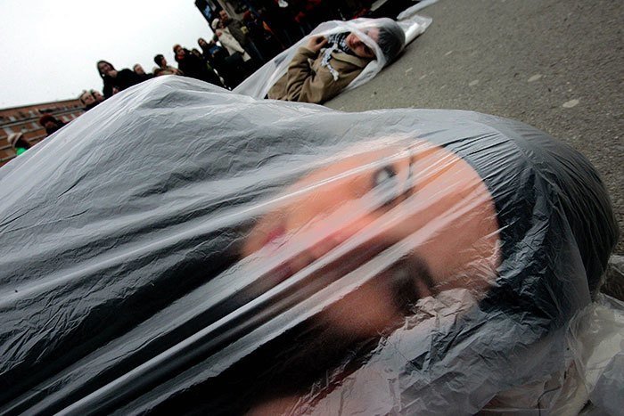 Участница международной организации "Женщины в чёрном" (выступающей за мир), лежит в пакете в знак протеста, Нови-Сад, Сербия, 2005