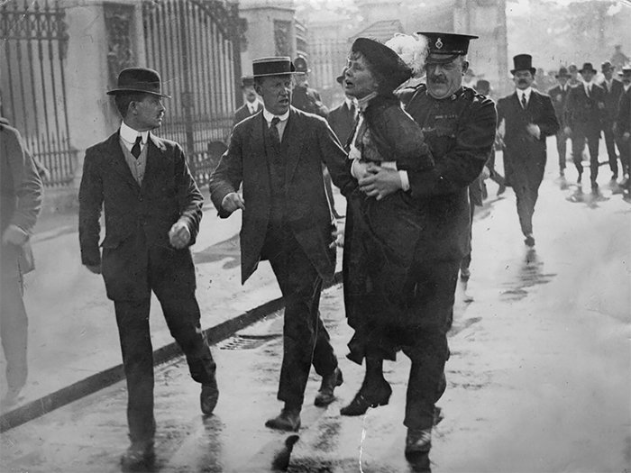 Суфражистку (участницу движения за предоставление женщинам избирательных прав) Эммелину Панкхёрст арестовывают на демонстрации, Лондон, 1914. Только в 1928 году на территории Британской империи женщины были уравнены в избирательном праве с мужчинами