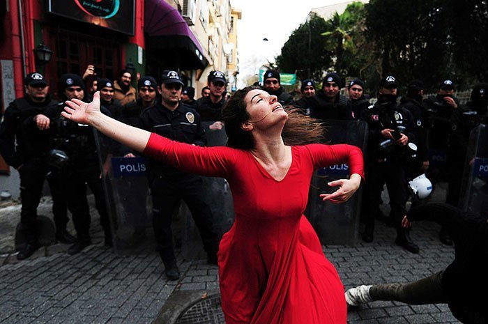 Девушка танцует перед полицией на демонстрации против выселения из "просевшего" здания, Стамбул, 2014