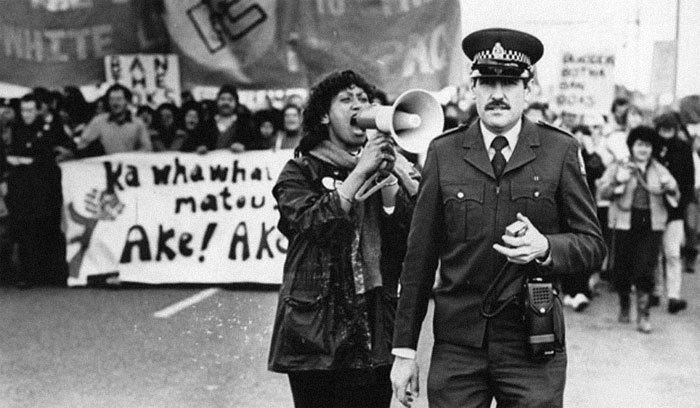  Женщина кричит на полицейского во время демонстрации против апартеида (политики расового разделения), 1981