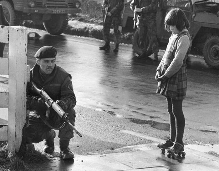 Девочка бесстрашно смотрит на солдата, который патрулирует в Северной Ирландии, 1969