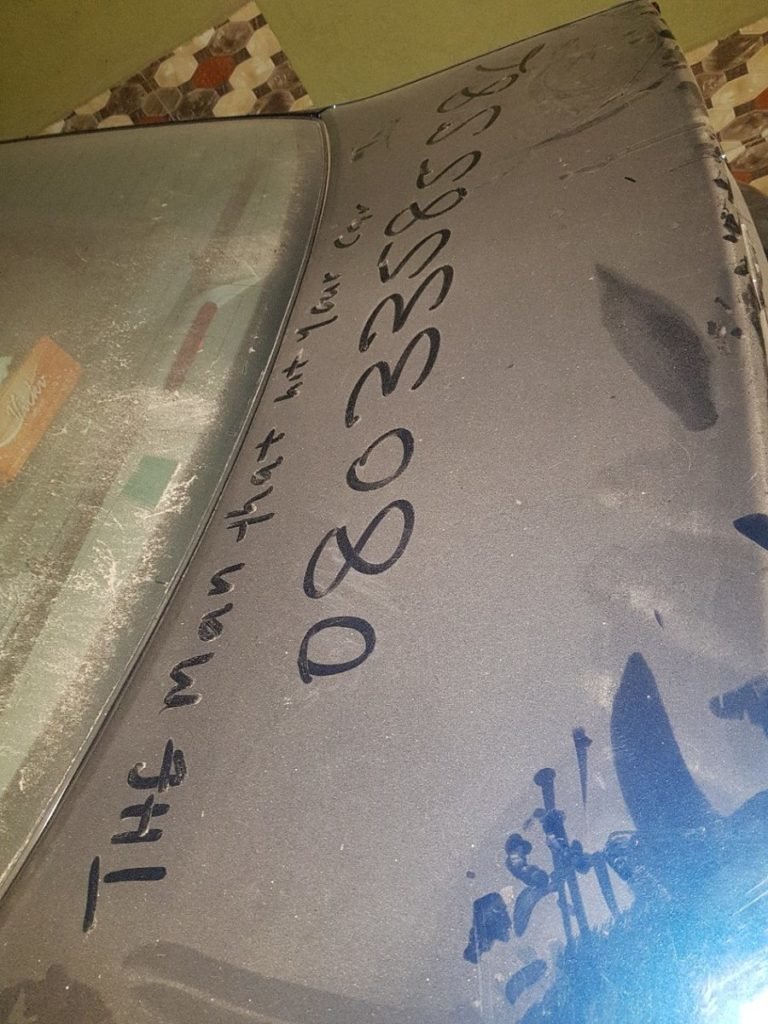 В Лагосе, Нигерия, неизвестный врезался в автомобиль Ларри МакКоя, но написал свой номер телефона на пыльном багажнике