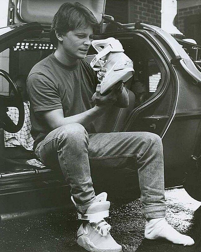 Майкл Дж. Фокс рассматривает кроссовки "из будущего" Nike MAG на съемках фильма "Назад в будущее 2", 1989 год 