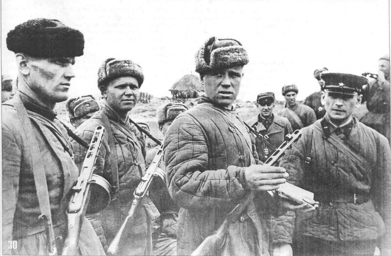 Советские разведчики докладывают о выполненном задании. Второй справа, с компасом и картой стоит разведчик Саморалов.
