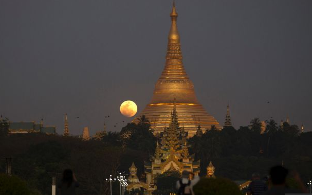 Суперлуна встает над пагодой Шведагон в городе Янгон, Мьянма