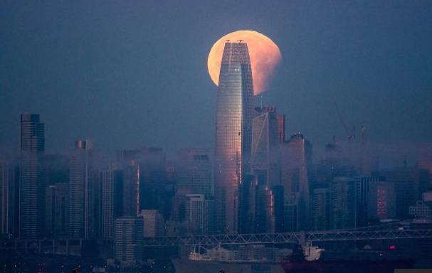 Громадная Луна над башней Сейлсфорс тауэр в Сан-Франциско