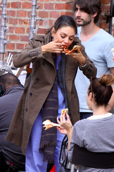 4. Актриса Мила Кунис с аппетитом поедает пиццу на съемочной площадке