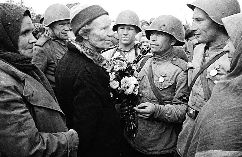 Мирные жители приветствуют советских солдат-артиллеристов истребительного противотанкового подразделения. 