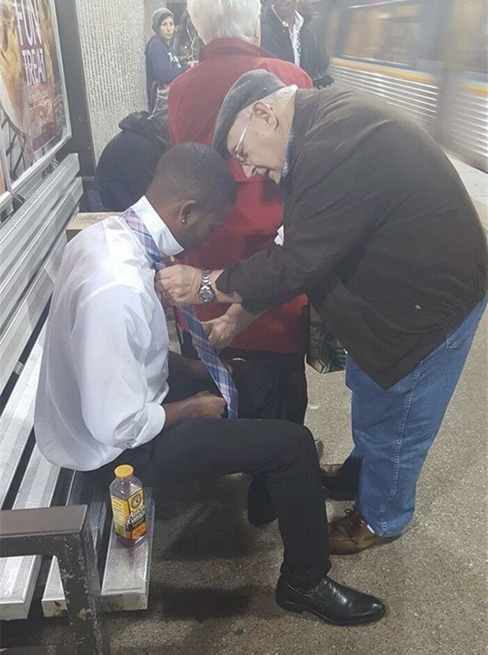 Мужчина помогает незнакомцу завязать галстук