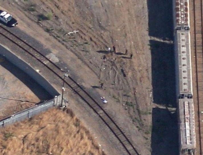 Это очень похоже на мертвое тело, лежащее возле железной дороги, рядом с которой полицейские ищут улики. очень надеемся, что это съёмки ещё какого-нибудь шоу
