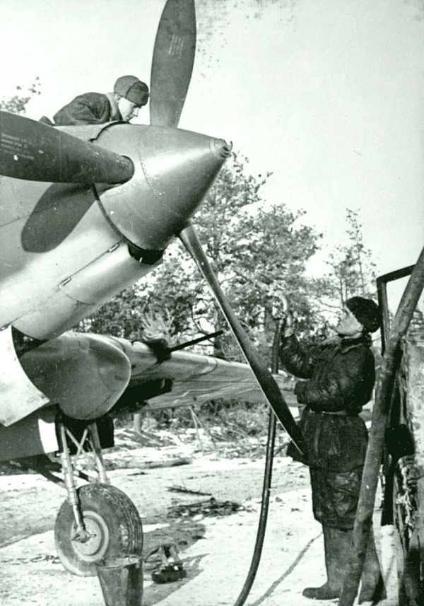 36. Советские авиамеханики заправляют топливом штурмовик Ил-2 на зимнем аэродроме.