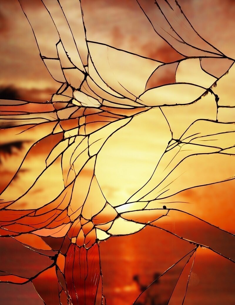 Солнечный закат сквозь разбитое стекло.