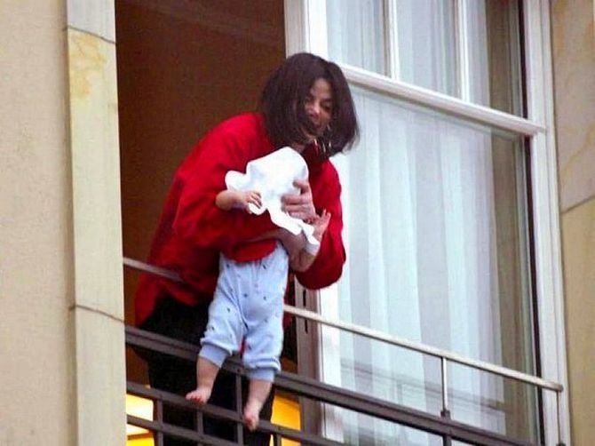 Майкл Джексон показывает дочку, свесив ее через перила балкона