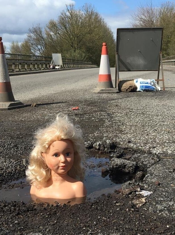 Ямочный ремонт по-английски: британец заделал дыру в дороге головами кукол