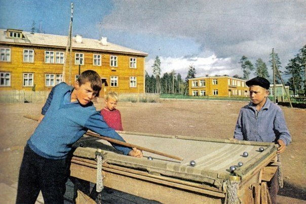 Мальчишки в Братске играют в бильярд, сделанный своими руками, и покрытый старым одеялом. 1967 год