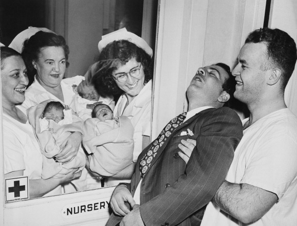 Сотрудники роддома показывают счастливому отцу его новорожденных тройняшек. Нью-Йорк, 1946 год.