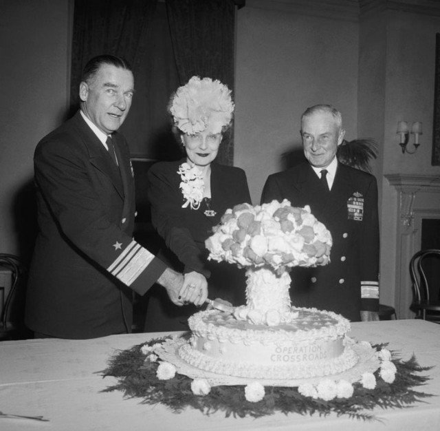 Адмирал Уильям Блэнди и его жена разрезают пирог в форме грибовидного облака, отмечая атомные испытания 1946 года на атолле Бикини.
