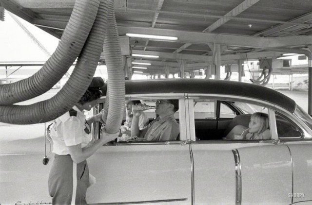 Холодный воздух подается в машину, пока ее пассажиры наслаждаются едой в ресторане формата drive-in. Хьюстон, 1957 год 