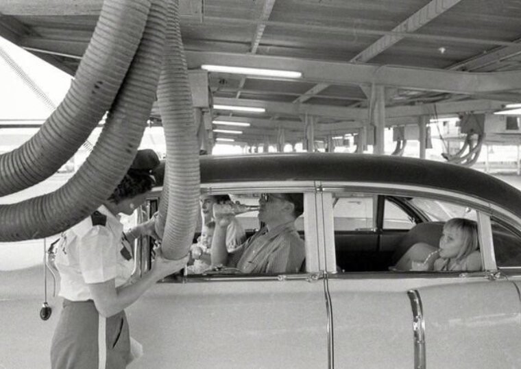В жаркую погоду сотрудники ресторана быстрого обслуживания подают холодный воздух в машину ожидающего заказа клиента. Техас, 1957