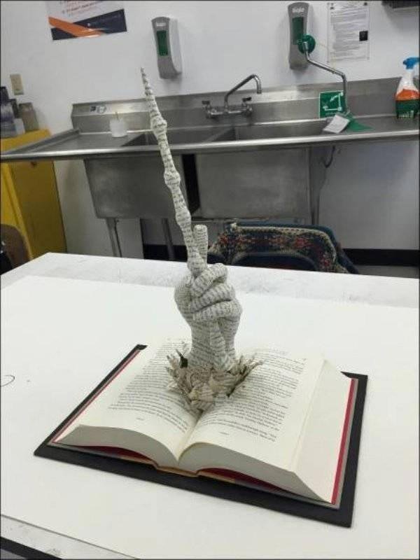 Скульптура из книжных страниц в виде руки волшебника с волшебной палочкой