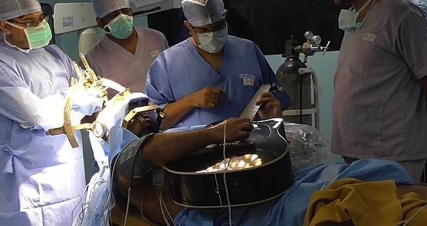 Пациент играет на гитаре во время операции на мозге