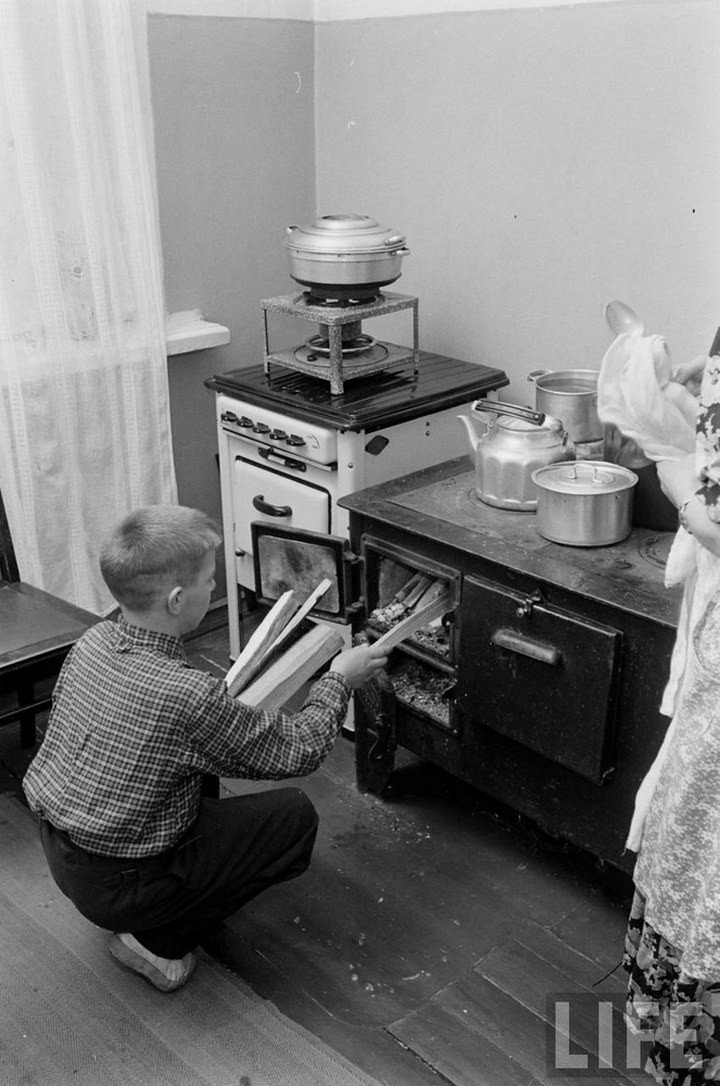СССР, 1955 г. В семью ленинградского рабочего привезли газовую плиту, но еще не подключили. Пока готовят на старой, которую топят дровами. Фотограф Эд Кларк, журнал LIFE
