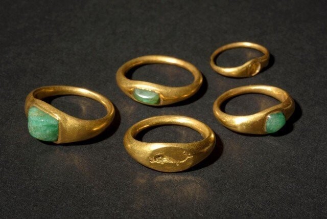 Пять золотых колец-перстней: три из них с изумрудами, в одном камень потерян, еще один - перстень-печатка 