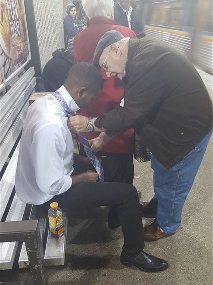 Пожилой мужчина помогает незнакомцу завязать галстук