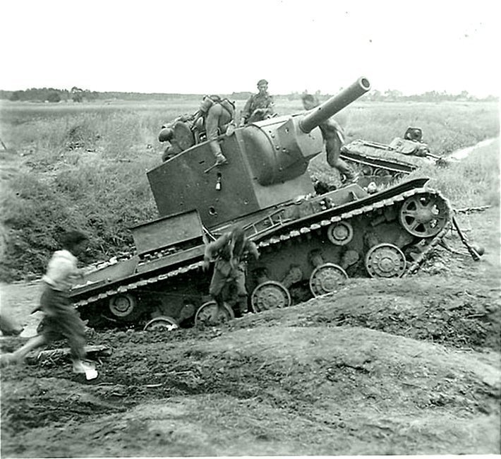 Немецкие солдаты рассматривают советский танк КВ-2, застрявший в ручье Майданский.   Место съемки: Львовская область, Украина.  Время съемки: 23-29.06.1941