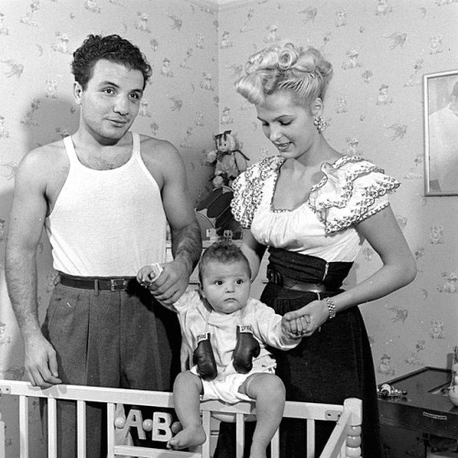  Джейк ЛаМотта-  у него была замечательная карьера боксера в среднем весе. Фильм М. Скорсезе «Бешеный бык» основан на его мемуарах 1970 года. ЛаМотта изображен здесь в 1947 году со своей второй женой Викки и их ребенком.