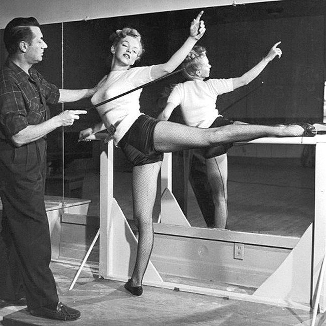 22-летняя старлетка Мэрилин Монро, практикующая балет во время урока с инструктором по танцам Нико Чариссе в Голливуде, Калифорния, 1948.