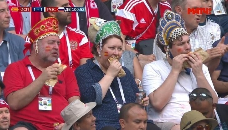 Бонус: болельщики с хот-догами и в кокошниках, которых показали по телевизору во время матча Россия — Испания, стали мемом и прославились   